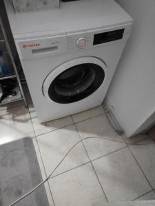 a white washing machine with a toilet in a kitchen at Casa Mocanu in Giurgiu