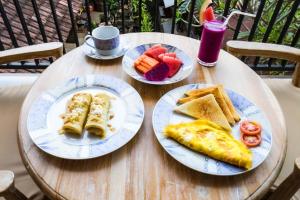 a table with two plates of breakfast food on it at Peanut House in Ubud