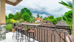 a balcony with bar stools and a view of the jungle at Peanut House in Ubud