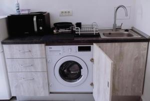 a kitchen with a washing machine and a sink at Lorena’s Apartment in Arad