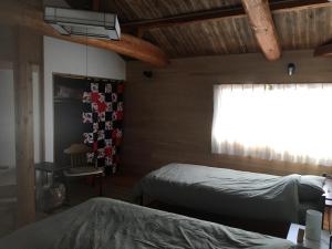 1 dormitorio con 2 camas y ventana en MOMO HOUSE, en Inami