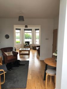 uma sala de estar com mesa e cadeiras em Aga Cottage 