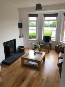 un salon avec une table basse et une cheminée dans l'établissement Aga Cottage, à Headwood