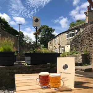 twobeer mugs sitting on top of a wooden table at Poppy's Place in Oakworth