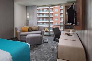 a hotel room with a bed and a living room at Courtyard by Marriott Guatemala City in Guatemala