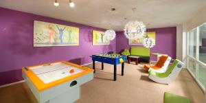a childrens room with a pool table and a room with purple at Almhotel Hochhäderich in Riefensberg