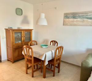 una sala da pranzo con tavolo e sedie di Apartamento Es Calo (Edificio Cavall de Llevant) a Es Caló de Sant Agustí