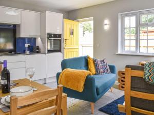 The Den في هيرن باي: غرفة معيشة مع كرسي ازرق وطاولة
