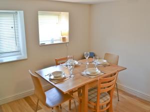 a dining room with a wooden table and chairs at Grey Ladies in Aylmerton