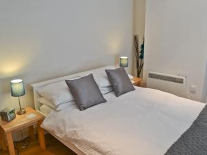 a bedroom with a white bed with two pillows at Grey Ladies in Aylmerton