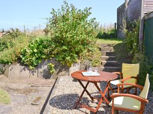 a table and chairs sitting on a gravel patio at Grey Ladies in Aylmerton