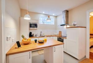 a kitchen with white cabinets and a wooden counter top at La Porte Enchantée in Chartres +3 photos