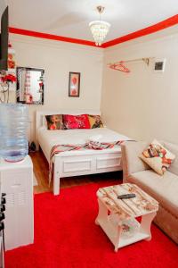 - une chambre avec un lit blanc et un tapis rouge dans l'établissement GEOLYN AIRBNB Naivasha, à Naivasha