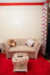 a living room with a couch and a coffee table at GEOLYN AIRBNB Naivasha in Naivasha