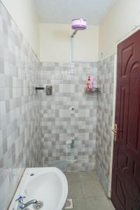 La salle de bains est pourvue d'un lavabo et d'une porte rouge. dans l'établissement GEOLYN AIRBNB Naivasha, à Naivasha