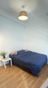 Bett in einem Zimmer mit einer blauen Decke und einem Tisch in der Unterkunft Digital Nomad House KL Bukit Bintang - Self service shared bathroom apartment in Kuala Lumpur