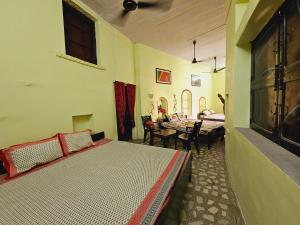 1 dormitorio con 2 camas, mesa y sillas en Haveli Gulabram Ji, Bundi, en Bundi