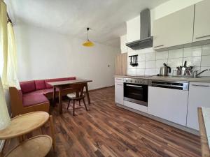 cocina con sofá rojo y mesa en Ferienhaus ZUR ALTEN FORSTKANZLEI, en Wald