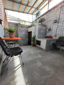 a patio with a table and chairs and a brick wall at Мини дом целиком около мед центра Астхик in Yerevan