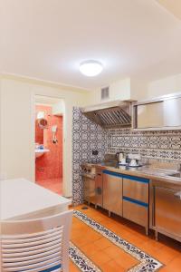 a kitchen with stainless steel appliances and a bathroom at Maison Tofani in Sorrento