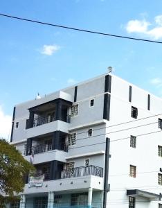 - un bâtiment blanc avec des balcons sur le côté dans l'établissement GEOLYN AIRBNB Naivasha, à Naivasha