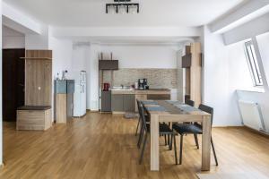 a kitchen and dining room with a table and chairs at Central apartments - Red in Bacău