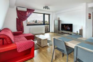 a living room with a red couch and a table at Central apartments - Red in Bacău