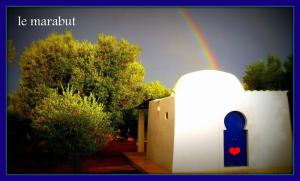 Un arcobaleno nel cielo sopra una casa con un arcobaleno di Case d'Artista a Savelletri