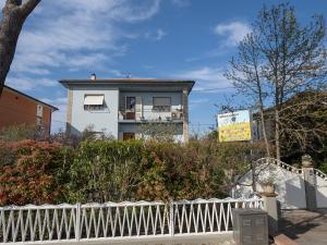 Uma casa branca com uma cerca branca à frente. em I Girasoli di Migliarino em Migliarino