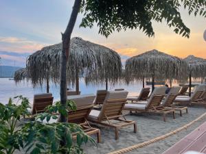 un grupo de sillas y sombrillas en una playa en Hotel Pavlou, en Poros