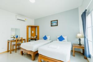 a bedroom with two beds and a table and a desk at Lamphurai Riverside Resort and Spa in Trat +55 photos