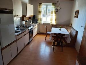 a kitchen with a table and a small kitchen with a table and a couch at Apartment Weintraube in Rohr im Gebirge
