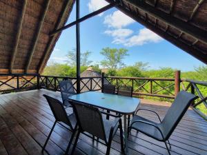 a table and chairs on a deck with a view at Giraffe plains in Marloth Park