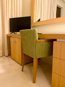 a computer desk with a chair and a television at Hotel Saraceno Al Faro in Taranto