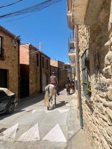 a person on a horse walking down a street at Habitaciones rurales en Colomers in Colomés