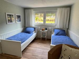 um quarto com 2 camas e almofadas azuis em Sonnige Souterrain-Ferienwohnung em Sassnitz