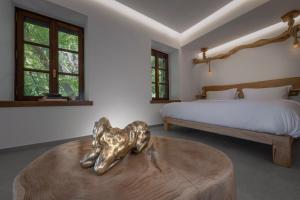 a bedroom with a bed and a table with a sculpture at Palios Stathmos in Miléai