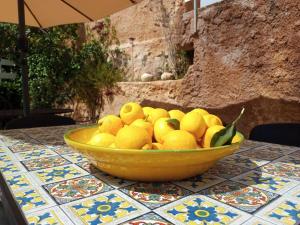 a yellow bowl of lemons sitting on a table at Terre di mare near the sandy beach with pool, parking & wifi in Fontane Bianche