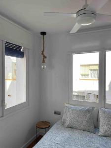 a bedroom with a bed and a ceiling fan at Marina Beach Aiguadolç Sitges in Sitges