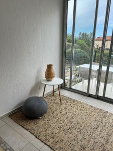 a vase sitting on a table next to a window at Au Petit Bonheur vue mer, parking, 400m plage in Le Lavandou