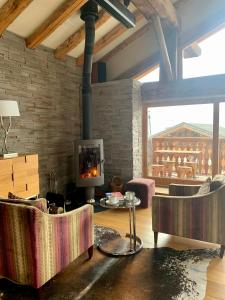 a living room with chairs and a fireplace at Chalet Violettes in Villaroger