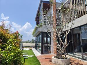 a house with a tree in a courtyard at Ocean Nadi 4 Bedrooms Beachfront Villa PD in Port Dickson