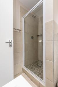 a shower with a glass door in a bathroom at 67 The Shades - Luxury Apartment in Umhlanga - Airconditioning throughout and Inverter in Durban