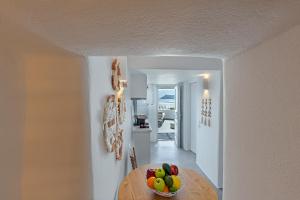 eine Küche mit einem Tisch und einer Schale Obst in der Unterkunft Helianthus Suites- Caldera Caves in Oia