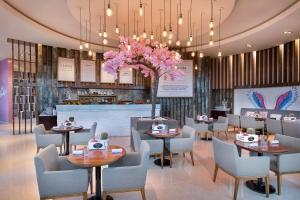 a restaurant with tables and chairs and pink flowers at W Dubai - Mina Seyahi in Dubai