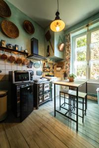 une cuisine avec des murs verts, une table et un comptoir dans l'établissement Chambre Bounty cuisine privée, salle d'eau, terrasse, garage, à Olliergues