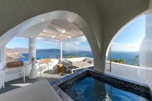 una piscina en una casa con vistas al océano en Helianthus Suites- Caldera Caves, en Oia