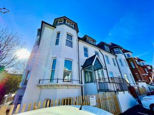 um grande edifício branco com uma cerca em frente em Tower House Apartments em Bournemouth