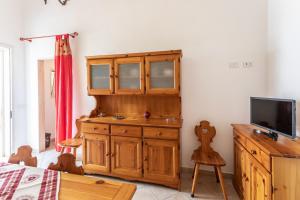 um quarto com um armário de madeira e uma televisão em Villetta Bianca em Gallipoli