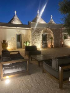 un patio con sofás y mesas frente a un edificio en Trulli Conca d oro La lamia, en Martina Franca